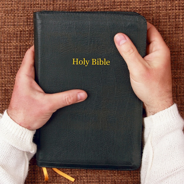 La santa biblia en manos del hombre