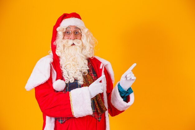 Santa Claus apuntando hacia el lado con espacio para texto