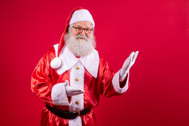 Santa Claus apuntando a un lado, publicidad promoción de Navidad, anuncio de descuento de Navidad de año nuevo aislado sobre fondo rojo.