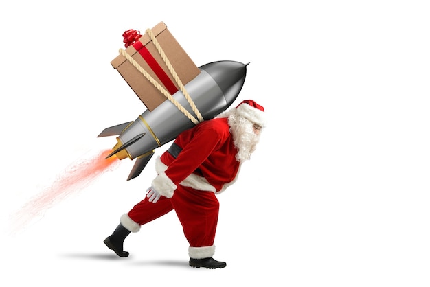 Santa Claus con caja de regalo de Navidad listo para volar con un cohete en el cielo