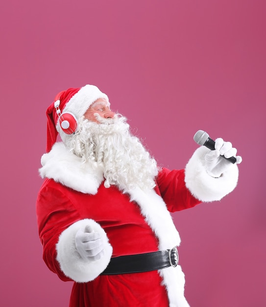 Santa Claus cantando canciones de Navidad sobre fondo de color