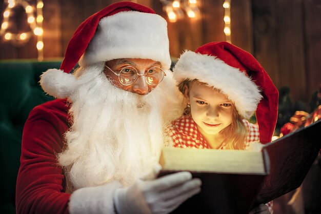 Santa Claus dando un regalo a una niña linda
