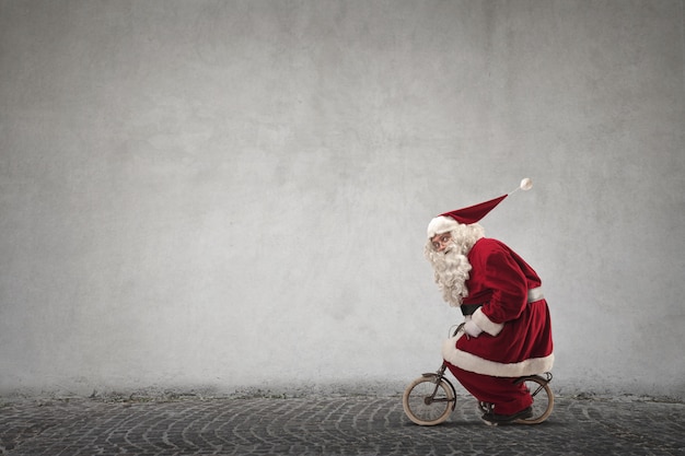 Santa Claus, die ein Minifahrrad fährt