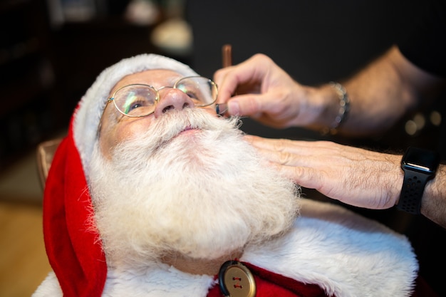 Santa Claus, die im Friseursalon sich rasiert