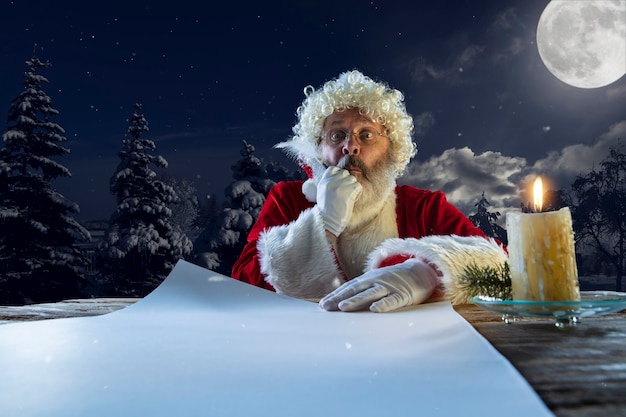 Santa Claus emocional felicitando con año nuevo y hombre de Navidad en escritura de cosume tradicional