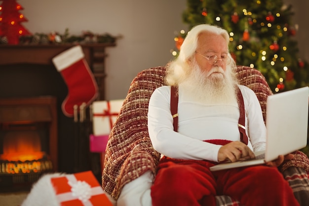 Santa claus escribiendo en la computadora portátil