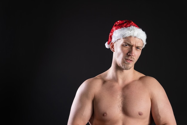 Santa Claus Fitness Bitseps demonstriert einen Athleten mit einer schönen Figur auf einem Schwarzen