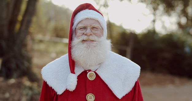 Santa Claus lächelnd in die Kamera schaut.