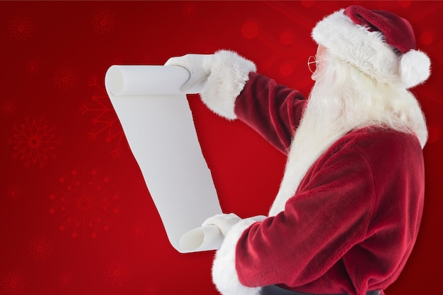 Santa Claus lee una lista con fondo rojo.