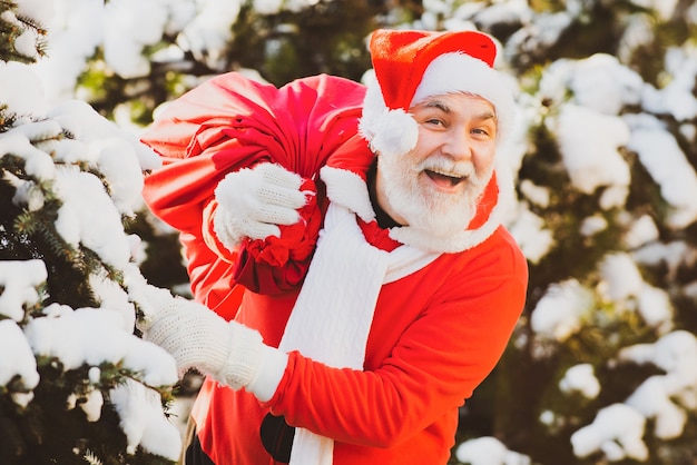 Santa Claus llevando una bolsa de regalos en invierno