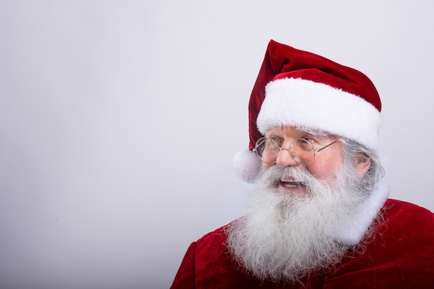 Foto santa claus, mirando un lado en la pared blanca