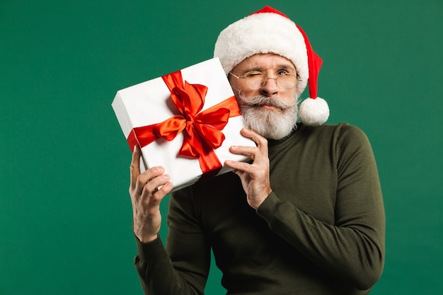 Santa Claus moderno barbudo tiene una caja de regalo