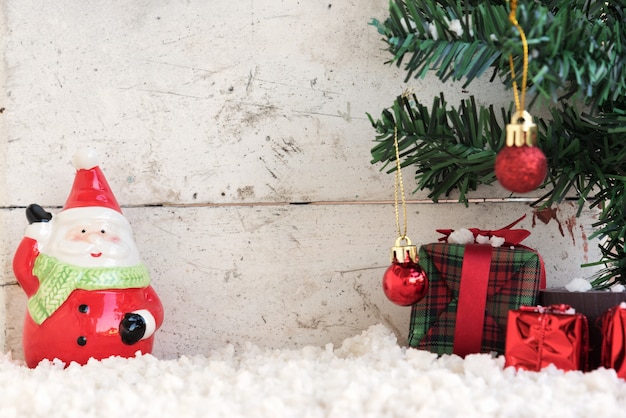 Foto santa claus en la nieve con el árbol de navidad en el fondo de la vendimia