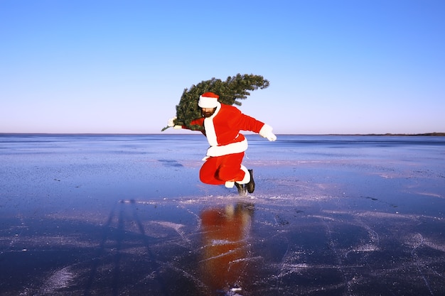 Santa Claus en patines de hielo va a Navidad. Santa Claus se apresura a cumplir con el Año Nuevo con regalos y árbol de Navidad.