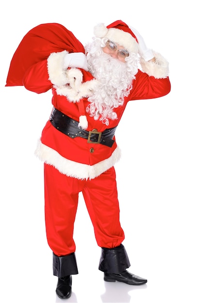 Santa Claus de pie con su saco lleno de regalos aislado sobre fondo blanco Retrato de longitud completa