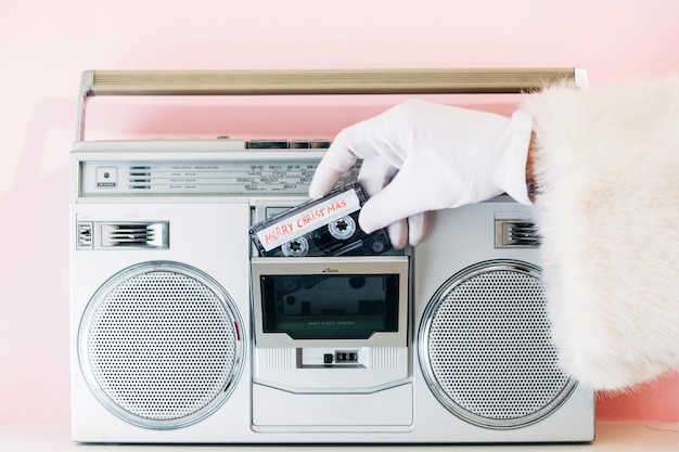 Santa Claus pone cinta de mezcla "Feliz Navidad" en boombox