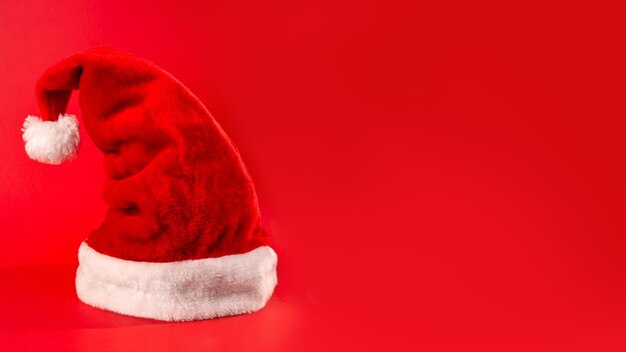 Santa Claus Red Hat auf rotem Hintergrund isoliert Frohes neues Konzept Flatlay Copyspace