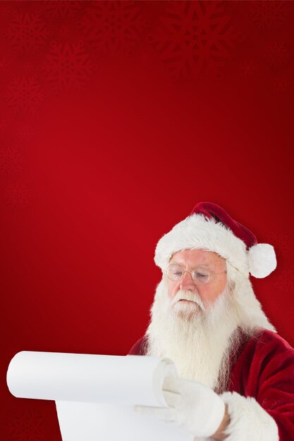 Santa claus revisando su lista contra el fondo rojo.