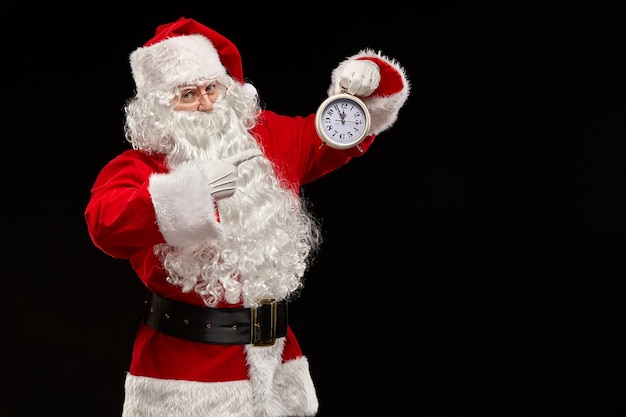 Santa Claus señala con el dedo el reloj.