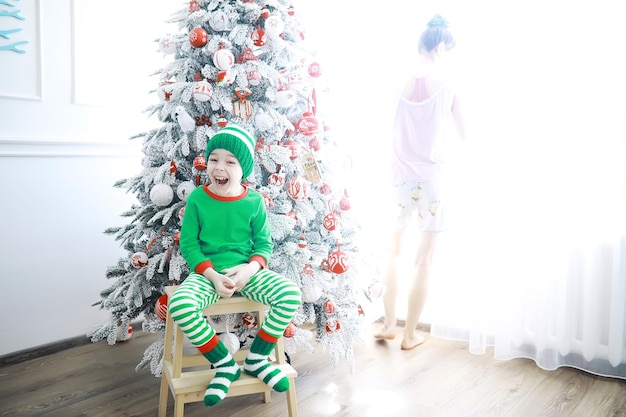 Santa Claus sitzt mit kleinen niedlichen Elfen über Weihnachten Hintergrund Zeit der Wunder Geschenke vom Weihnachtsmann