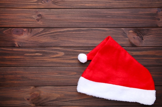Santa Claus sombrero rojo sobre fondo de madera marrón