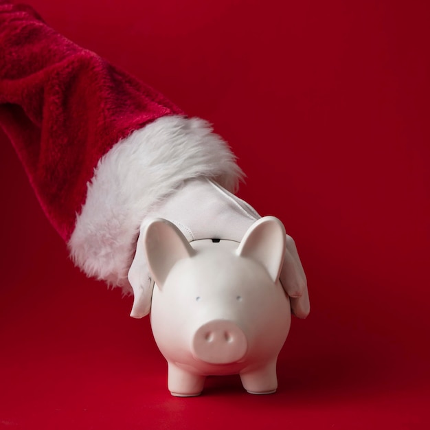 Santa claus sosteniendo un concepto de ahorro festivo de caja de dinero de alcancía de navidad