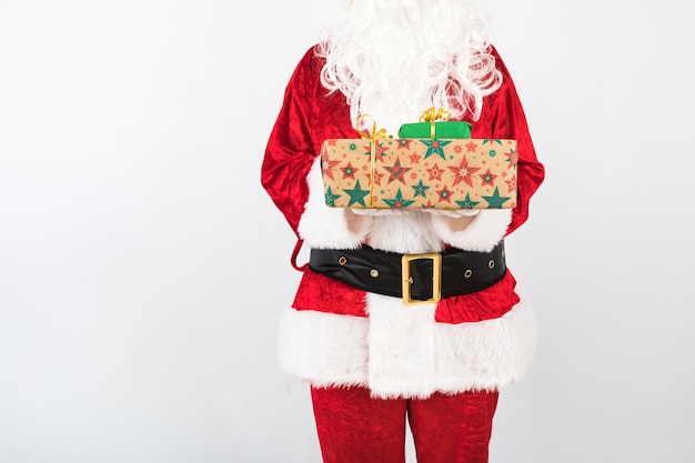Santa Claus tiene dos regalos sobre fondo blanco.