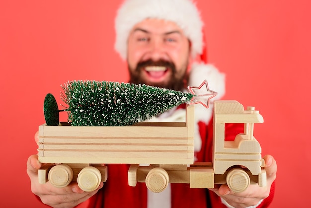 Santa Mann halten Spielzeugauto mit Weihnachtsbaum Weihnachtsfeiertag Neujahr Konzept selektiv