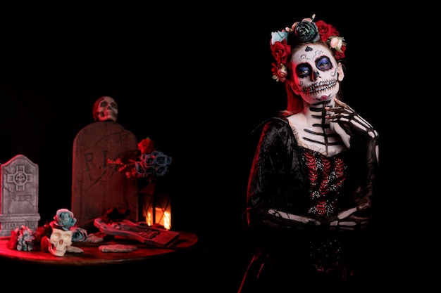 Santa muerte deusa agindo glamourosa no estúdio, usando maquiagem tradicional de caveira da morte e arte corporal. modelo feminino assustador com fantasia de halloween preta la cavalera catrina.