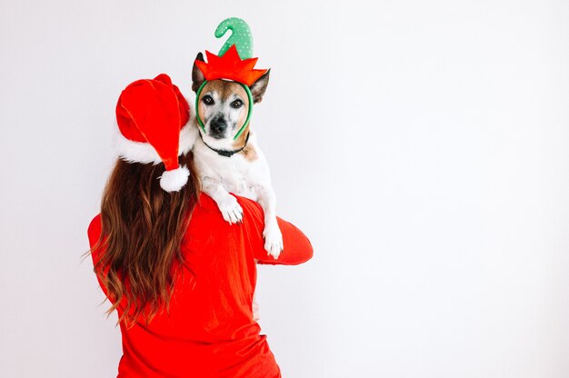 Santa mujer sosteniendo un concepto de Navidad de perro elfo