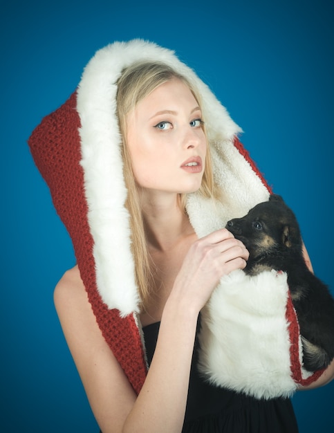 Santa niña bastante joven con sombrero de santa claus tiene concepto de amistad de pequeño amigo cachorro