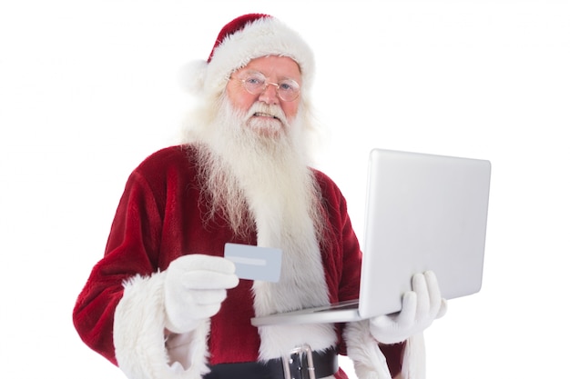 Santa paga con tarjeta de crédito en una computadora portátil