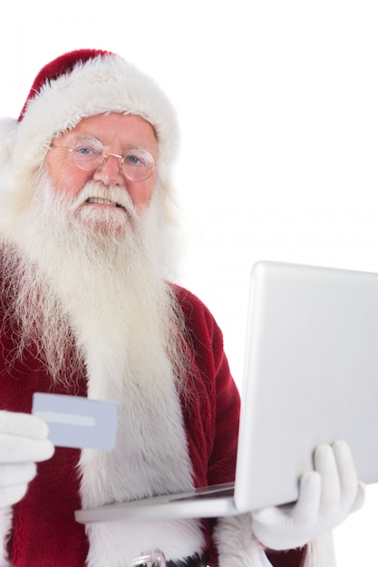 Santa paga con tarjeta de crédito en una laptop