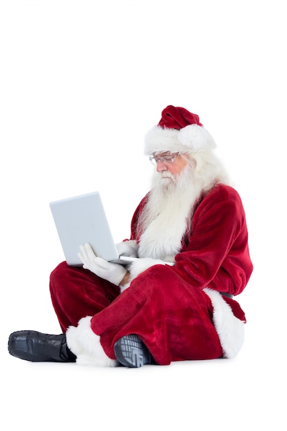 Santa se sienta y usa una computadora portátil