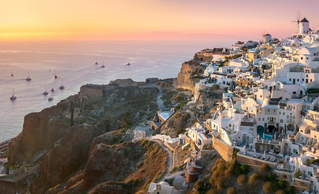 Santorini al atardecer La famosa ciudad de Oia al atardecer Una línea de veleros en el mar Vacaciones románticas Oia Santorini Grecia