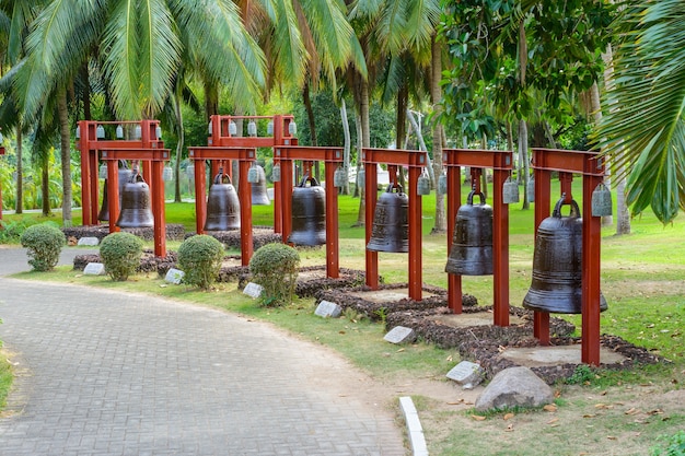 Sanya, Hainan, China - 20 de febrero de 2020: Las campanas del callejón con jeroglíficos chinos en el territorio del centro budista Nanshan.