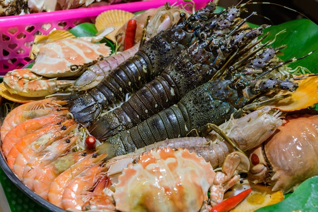 Sanya, Hainan / China - 7 de enero de 2020: comida callejera china. Comercio callejero. Tipos chinos de mariscos frescos en un mercado asiático de mariscos en Sanya, provincia de Hainan, China. Inscripción: nombre de la comida.