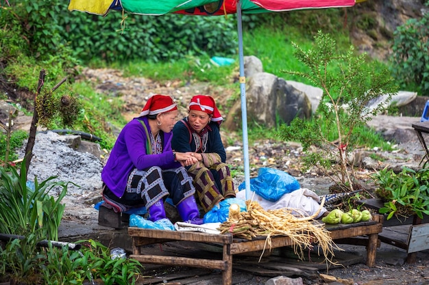 Sapa Vietnam Dos mujeres venden verduras bajo un paraguas Comercio callejero