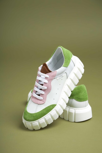 Sapatos brancos femininos de moda em fundo verde Sapatos de moda feitos de couro ecológico primavera verão 2022