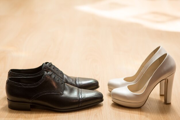 Sapatos da noiva e do noivo em parquet. fundo de casamento