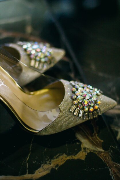 sapatos da noiva incrustados com pedras preciosas no chão de mármore, vista superior, foco suave