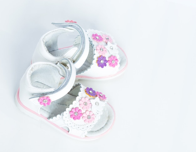 Sapatos de bebê brancos em um fundo branco