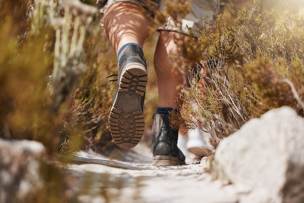 Sapatos de caminhada e homem em uma floresta para exercícios físicos e treino na natureza com closeup cardio matinal Alpinista de pés e esportista caminhando por um caminho na floresta relaxa zen e tranquilo