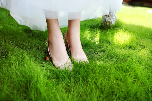 Sapatos de casamento da noiva na grama verde