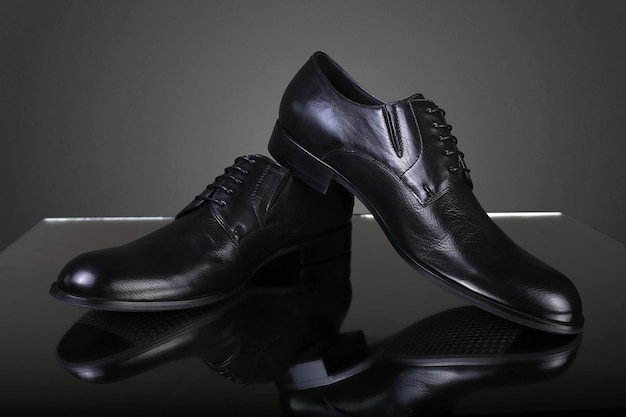 Sapatos de couro pretos masculinos clássicos em um fundo cinza