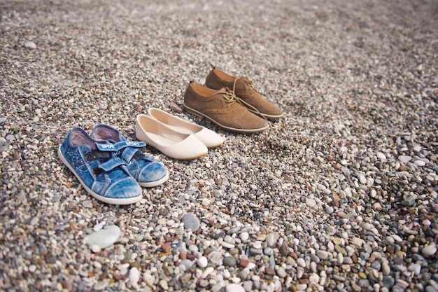 Sapatos de família na beira mar da praia 8640