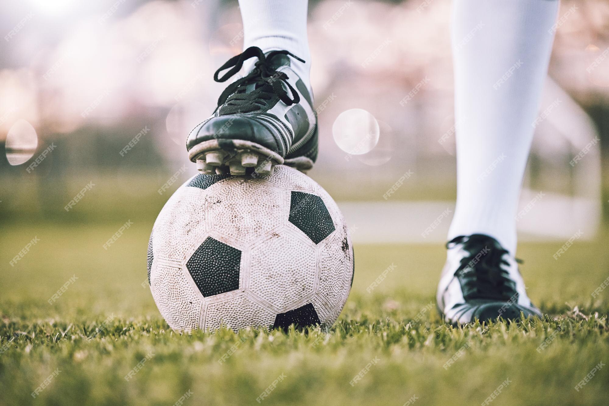 Sapatos de jogador de futebol de bola de futebol e campo de grama