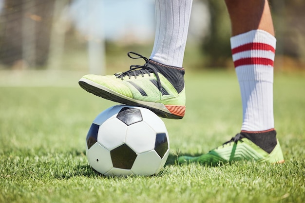 Sapatos de jogador de futebol de bola de futebol e pé no campo para iniciar jogos de competição e treinamento esportivo no campo de grama do estádio Jogador de futebol pés homem atleta ação e poder para marcar gols no relvado