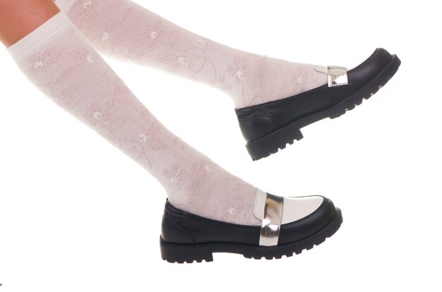 Sapatos de menina de couro preto brilho isolados no branco.