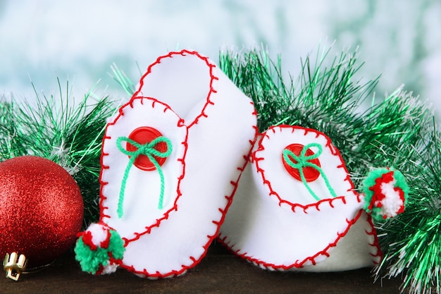 Sapatos de Natal com enfeites na mesa no fundo brilhante